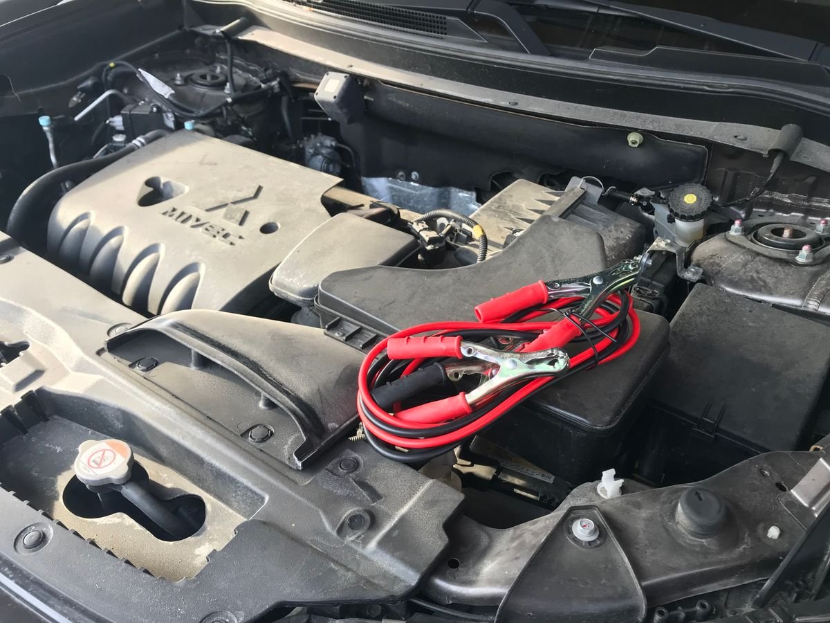 Cabos de bateria conectados no motor de um carro para dar partida